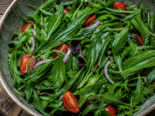 een salade met smalle weegbree en tomaten