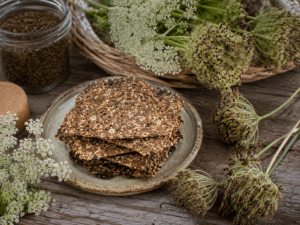 Wilde-peen zaadcrackers met zaden en wilde-peenzaden op een bord